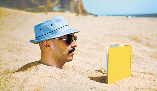 guy stuck in sand reading book